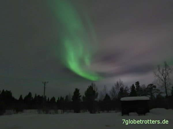 Nordlichter am bewölkten Himmel über Kiruna