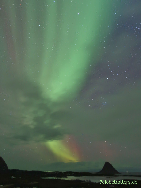 Rote und grüne Nordlichter über dem Atlantik in Norwegen beobachten
