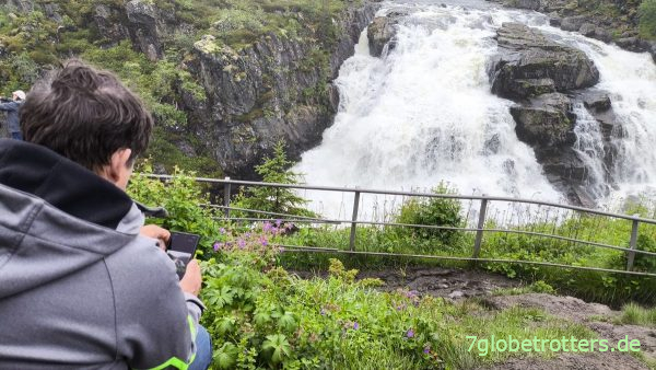 Der Vater fotografiert den Storchschnabel am Vøringsfossen Der Vater fotografiert den Storchschnabel am Vøringsfossen